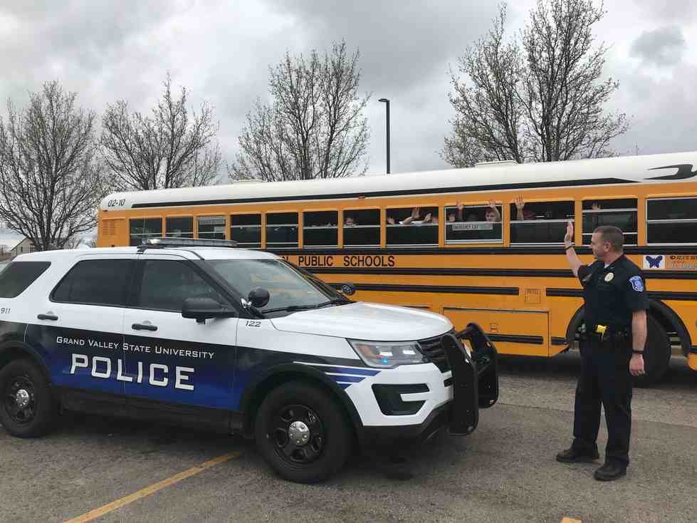 Officers waving at a school bus